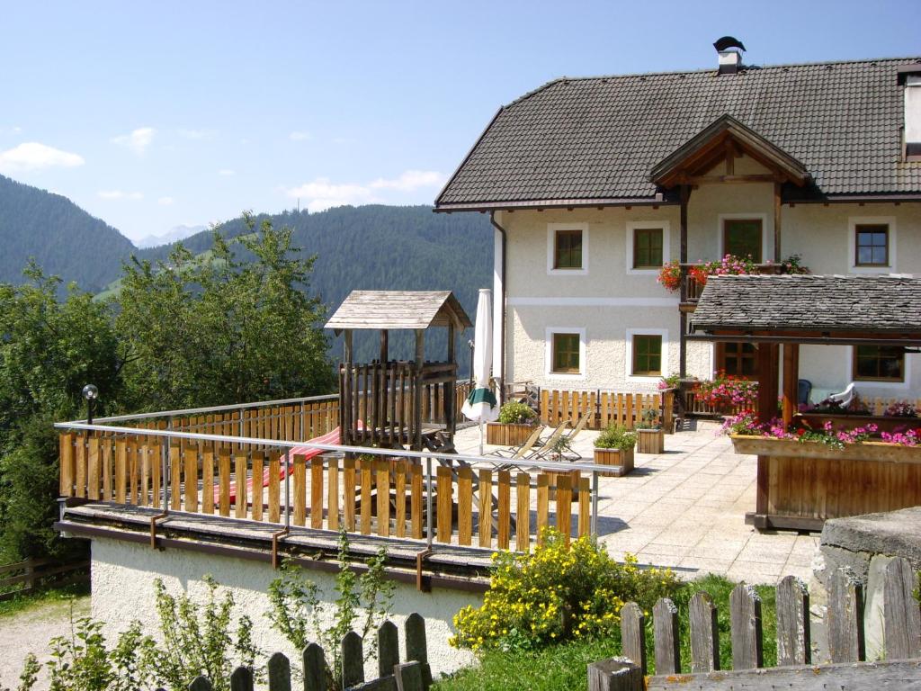dom z drewnianym tarasem obok domu w obiekcie Soroea w mieście San Vigilio di Marebbe