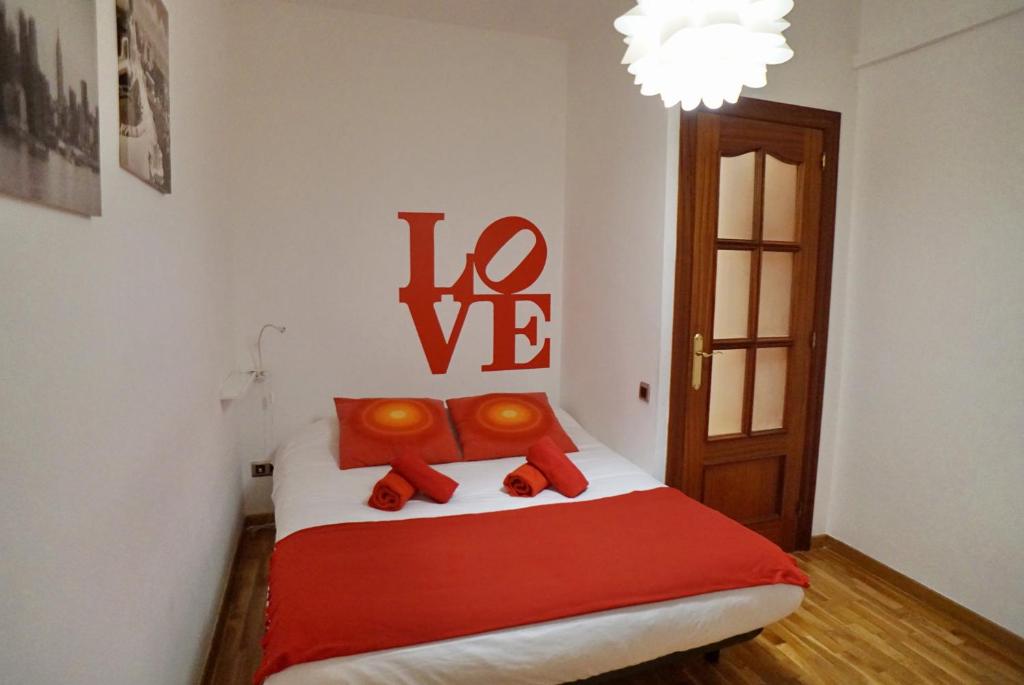 um quarto com uma cama com um cobertor vermelho e um lustre em Barcelona4Seasons - Miro em Barcelona