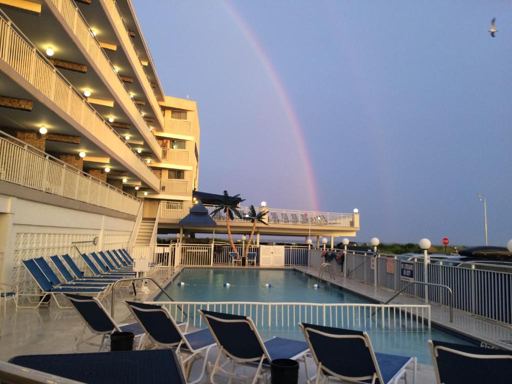 uma piscina num navio de cruzeiro com cadeiras e um arco-íris em Armada By The Sea em Wildwood Crest