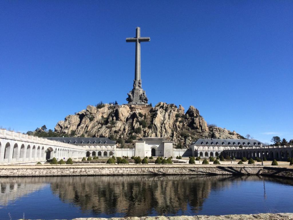 a church with a cross on top of a mountain at Hospedería Santa Cruz in San Lorenzo de El Escorial