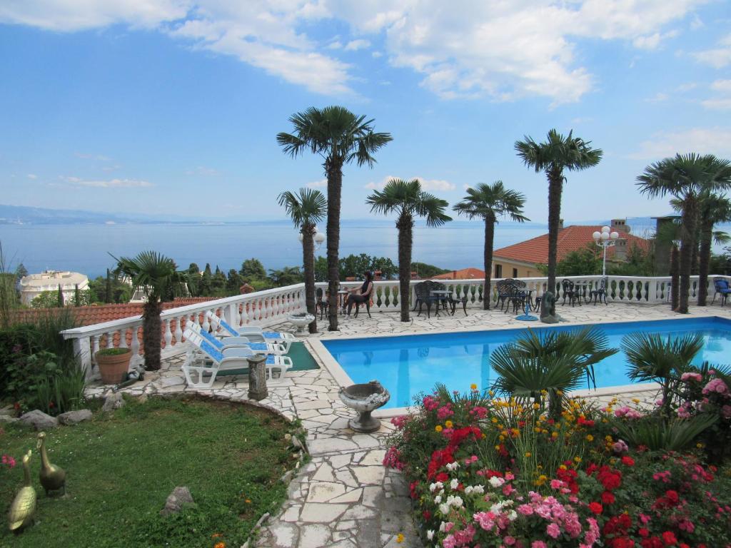 ośrodek z basenem i palmami w obiekcie Apartments Villa Palme w mieście Opatija