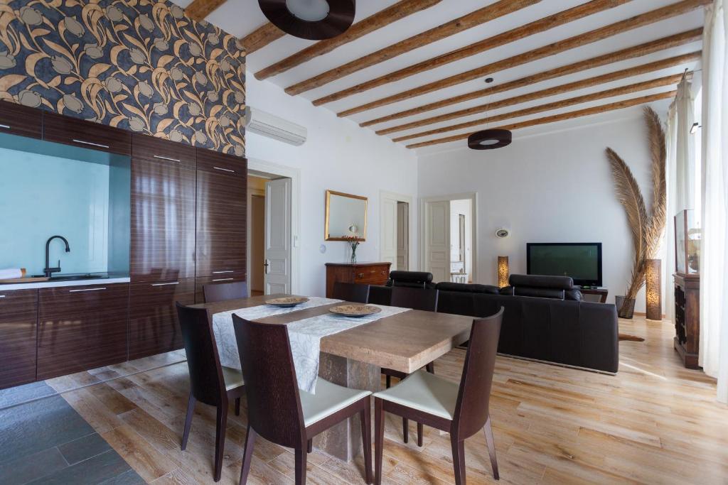 una sala da pranzo con tavolo e divano di Luxury Beachfront Apartment Banje a Dubrovnik