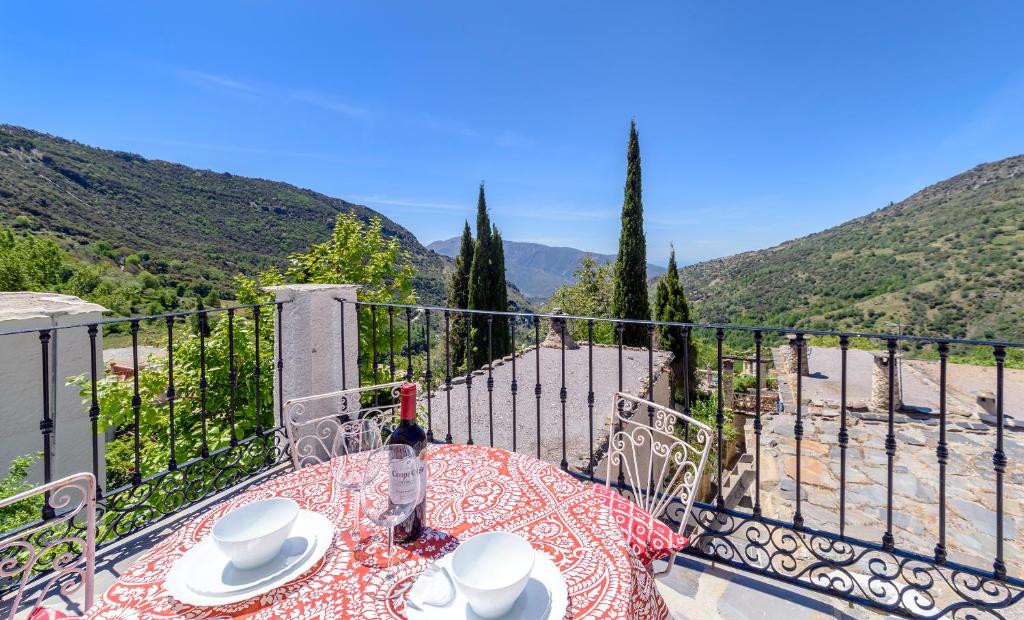 a table with a plate of food on a balcony at Casa Cecilia in Bubión