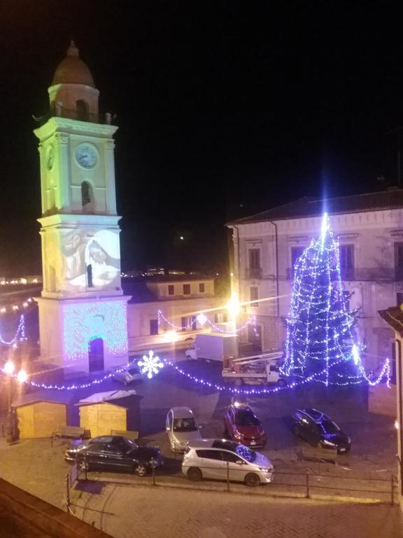 a christmas tree in front of a building with a clock tower at b&b Vallone del grano in Rossano
