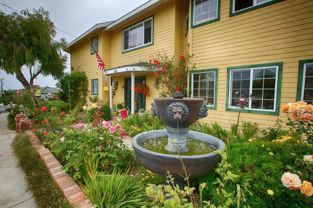 a garden with a fountain in front of a house at Marina Street Inn in Morro Bay