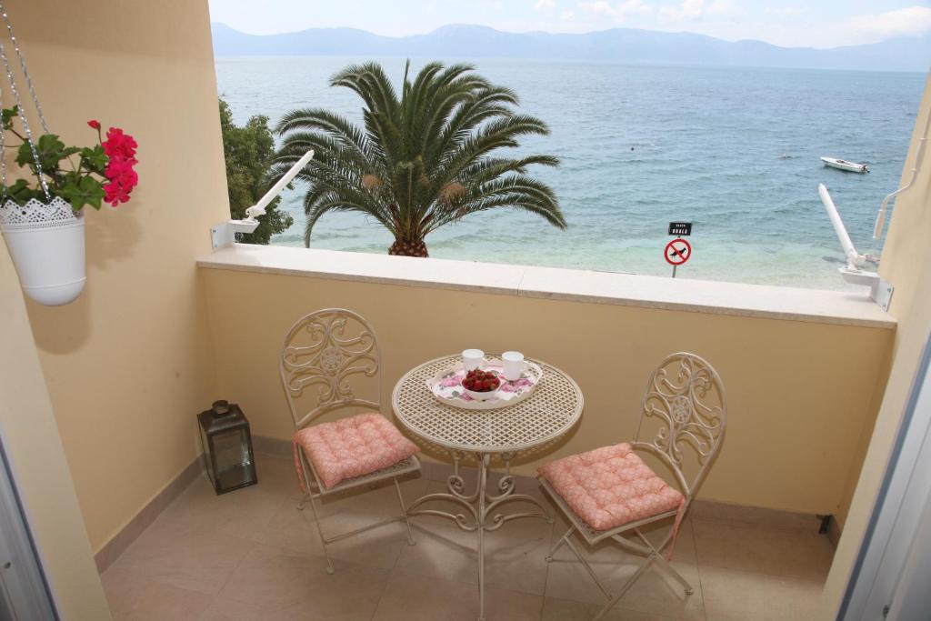 a balcony with a table and chairs and the ocean at Apartments Mare in Gradac