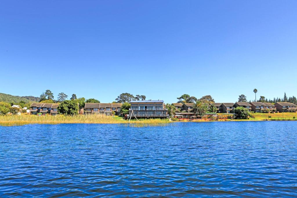 una gran masa de agua con casas en el fondo en Pine Lake Marina, en Sedgefield