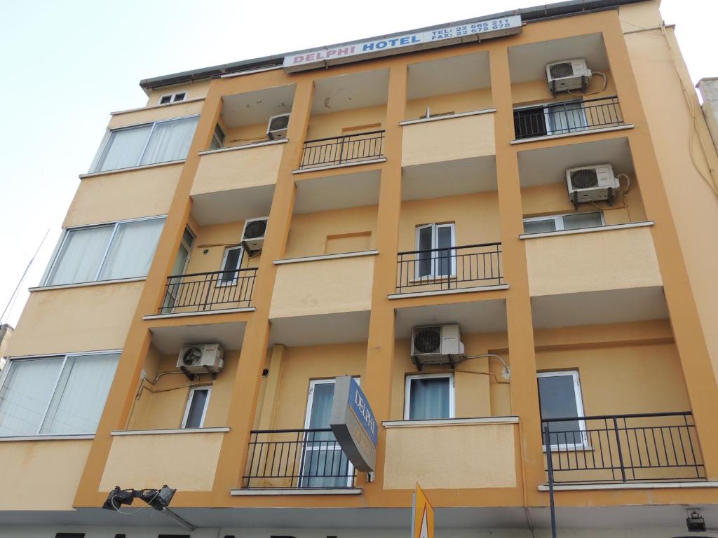 a yellow building with balconies and air conditioners at Delphi Hotel in Nicosia