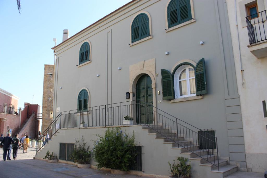 een wit gebouw met een trap naast een straat bij Holiday Home Casuzze in Marina di Ragusa