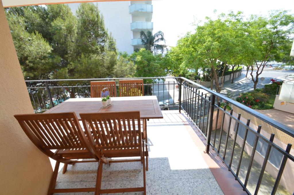 y balcón con mesa y sillas de madera. en Apartamento Playa Capellans - Salou, en Salou