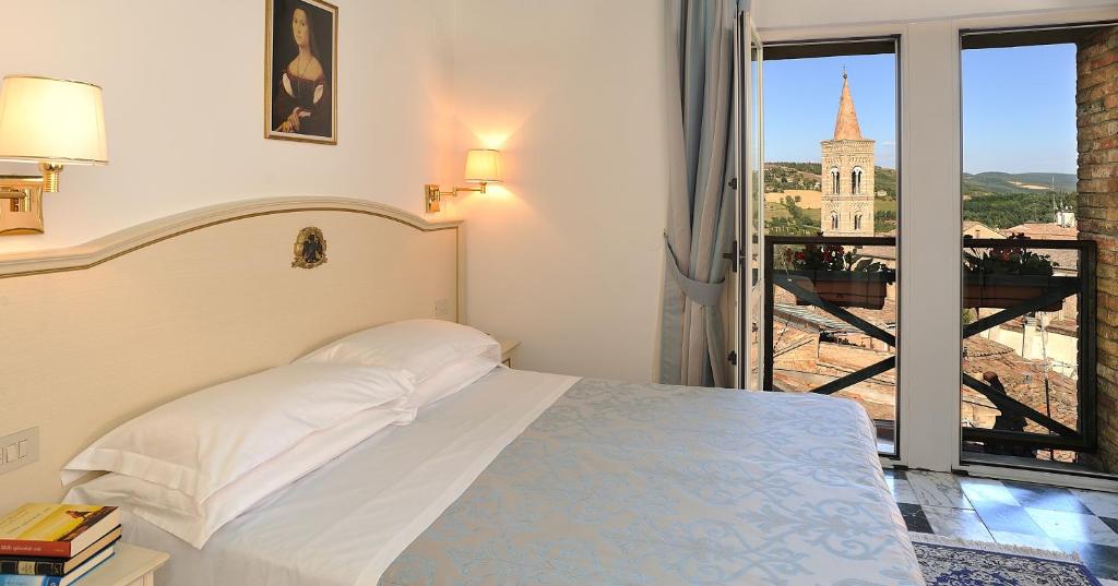 a bedroom with a bed and a view of a building at Hotel Raffaello - Self Check-in Free in Urbino