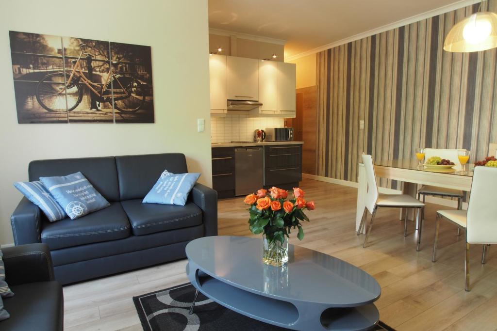 a living room with a couch and a table at Grand-Tourist Center Point Apartments in Gdańsk