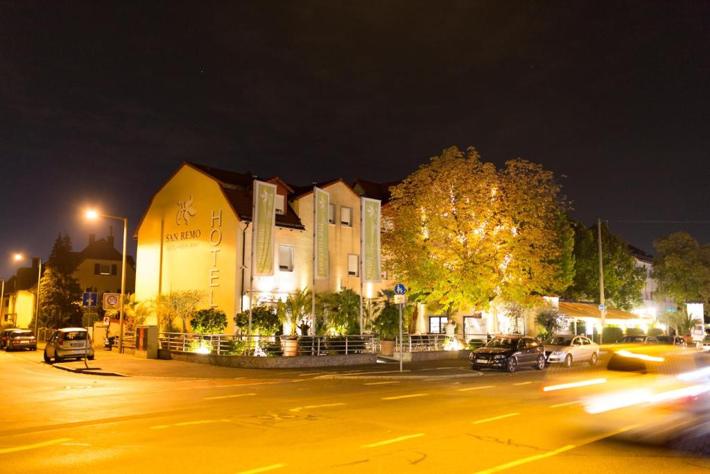 una calle de la ciudad por la noche con un edificio y coches en SAN REMO Fine.Food.Hotel, en Núremberg