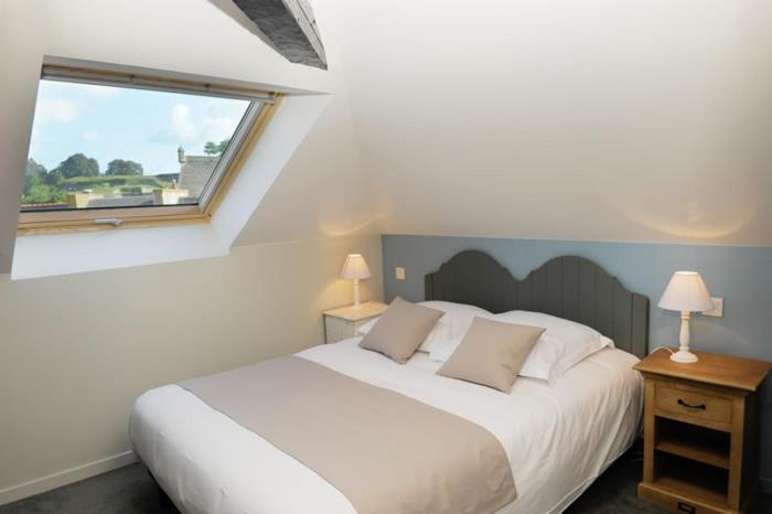 ein Schlafzimmer mit einem großen weißen Bett und einem Fenster in der Unterkunft Hôtel Restaurant Corto Maltese in Le Palais