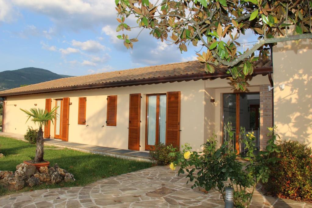 a small white house with wooden shutters at Valle Di Francesco in Assisi