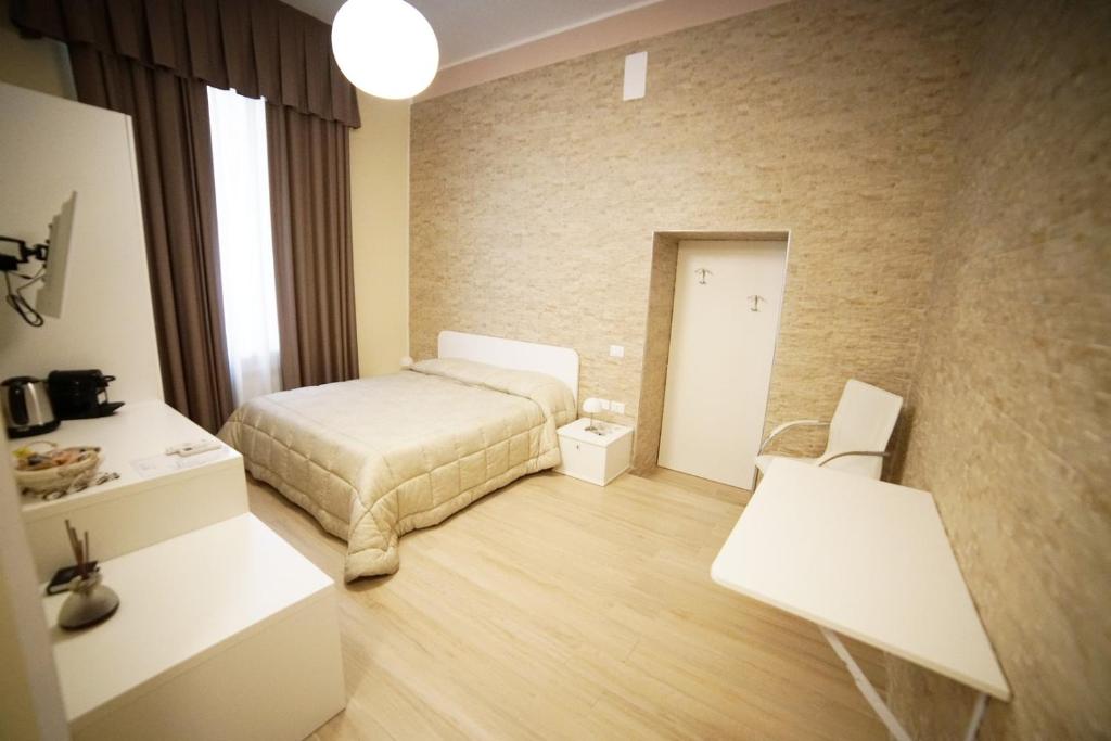 sypialnia z łóżkiem i dwoma białymi stołami w obiekcie Gattini33 w mieście Matera