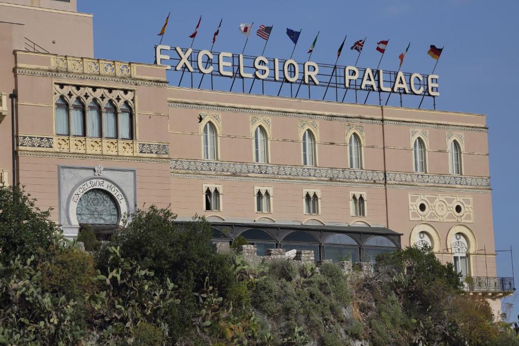 Un bâtiment avec un panneau en haut dans l'établissement Excelsior Palace Hotel, à Taormine