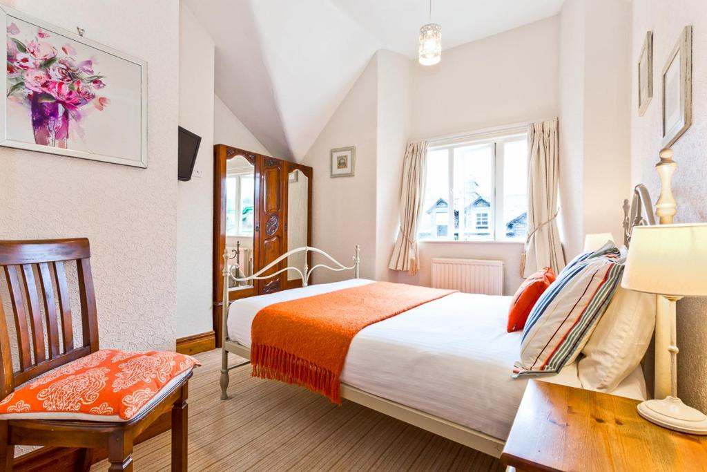 1 dormitorio con 1 cama, 1 silla y 1 ventana en 3 Cambridge Villas, en Ambleside