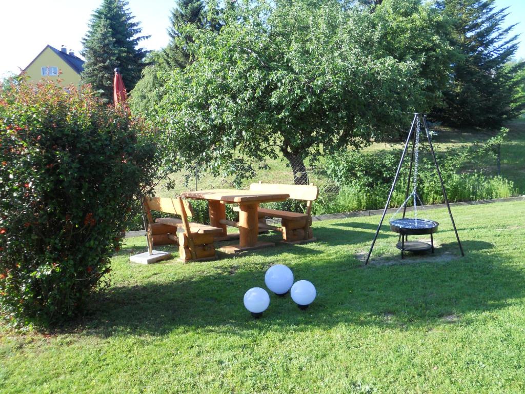 a picnic table and a swing and eggs on the grass at Ferienhaus Zittau in Zittau