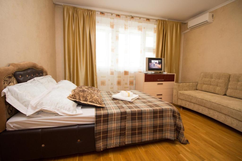 モスクワにあるApartment Bagrationovskayaのベッドルーム1室(ベッド1台、ソファ、窓付)