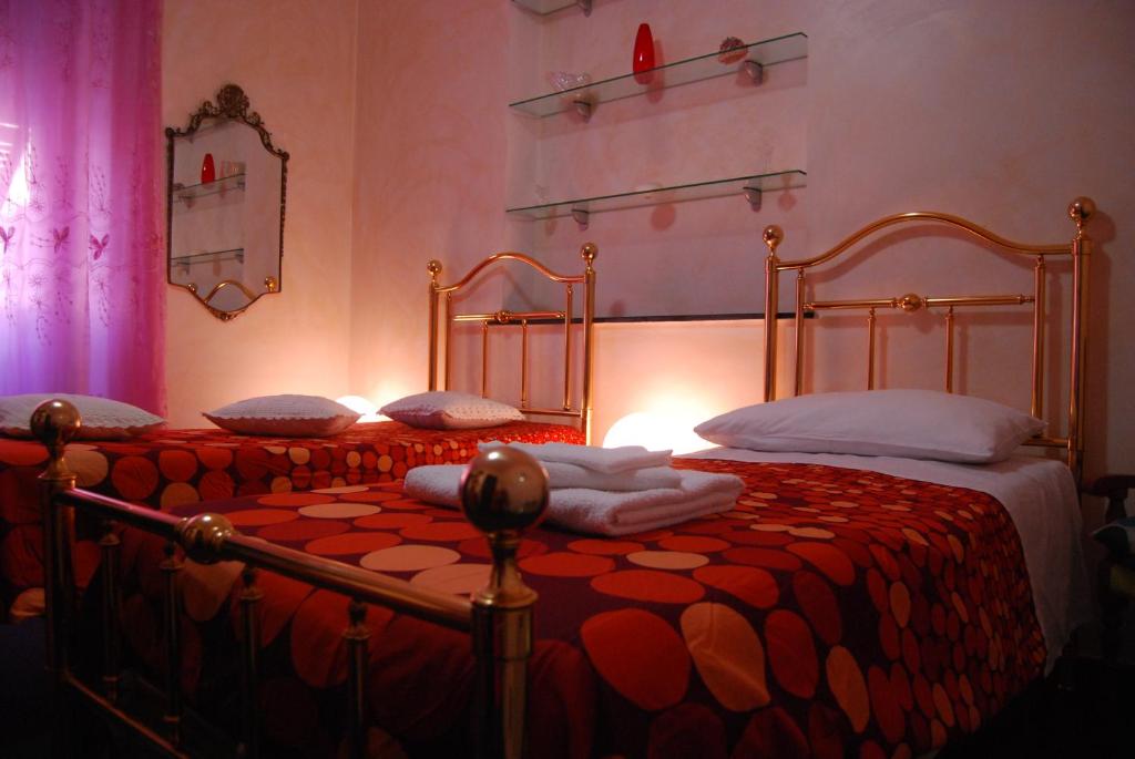 a bedroom with a bed with a red comforter at Casa MaMa in Genoa