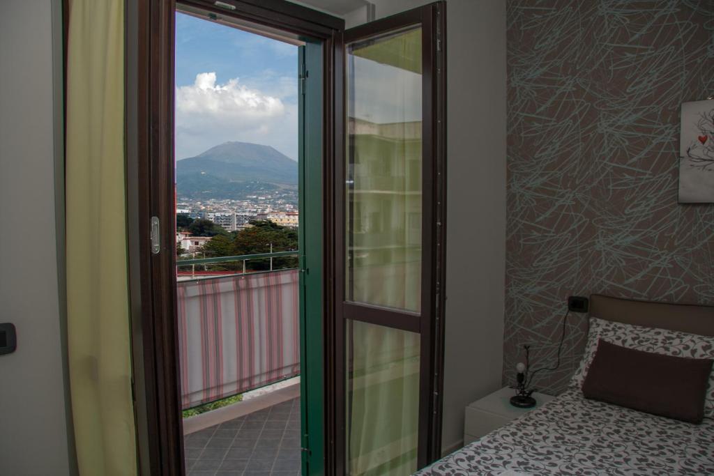1 dormitorio con balcón con vistas a la montaña en Luca Quaranta Apartment, en Nápoles