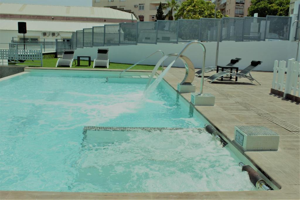 uma grande piscina com escorrega aquático em Deluxe Hostels & Suites Merida em Mérida