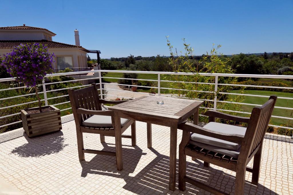 a wooden table and two chairs on a patio at Colina Verde Resort in Moncarapacho