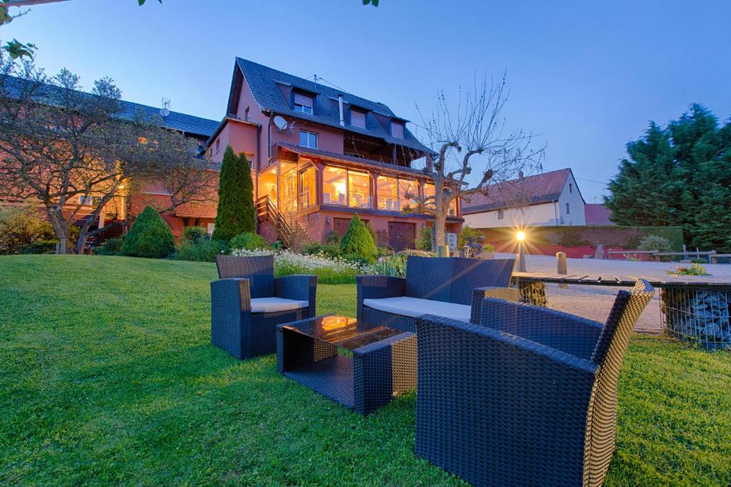 a large house with blue furniture in the yard at Hotel Restaurant des Vosges in Birkenwald