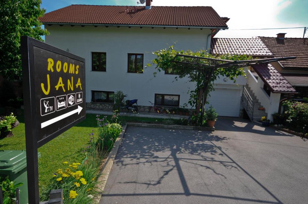 una casa con un cartel delante de ella en Rooms Jana en Slunj