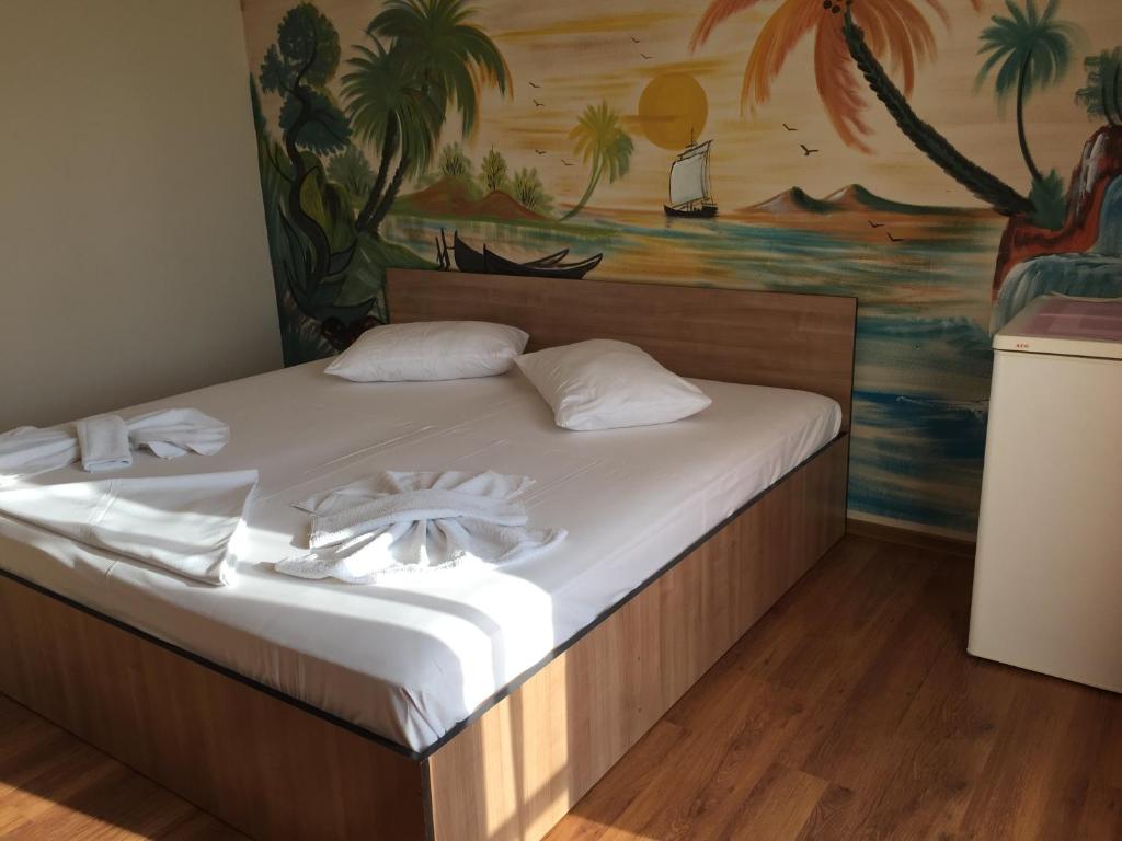 uma cama num quarto com uma pintura na parede em Vila Nusa em Eforie Nord