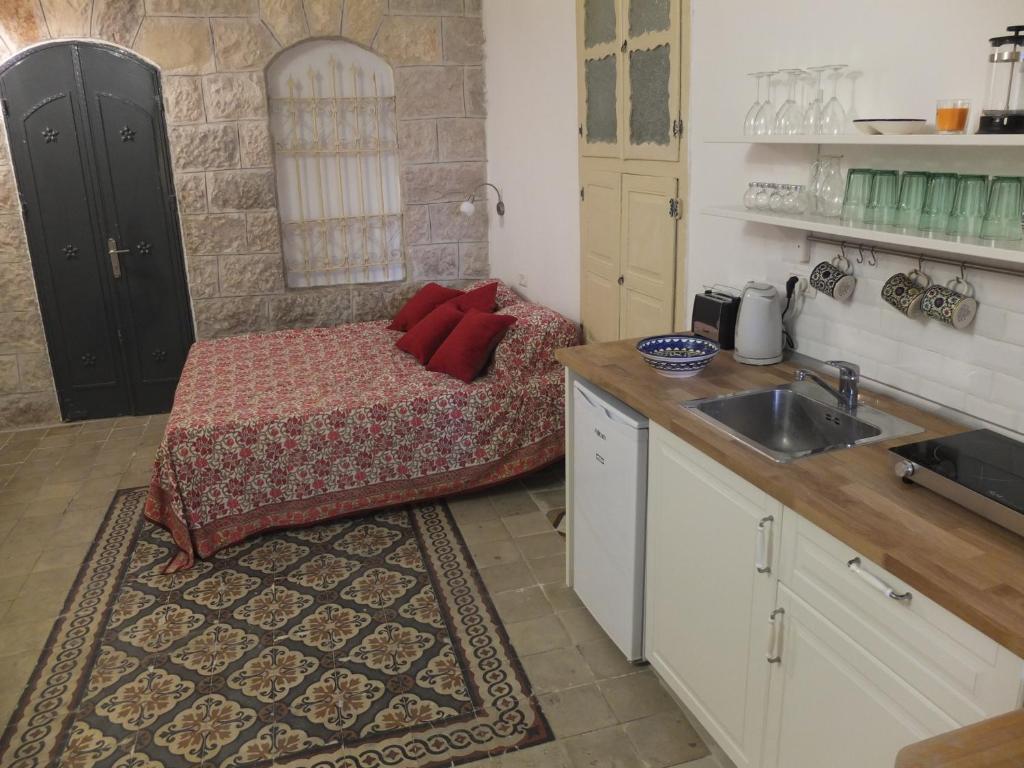 una pequeña cocina con cama y lavabo en Central old stone Jerusalem apartment, en Jerusalén