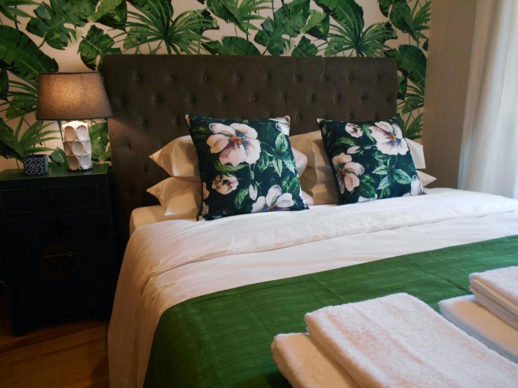 a bedroom with a bed with green and white pillows at Lisbon Garden Boutique Guest House in Lisbon