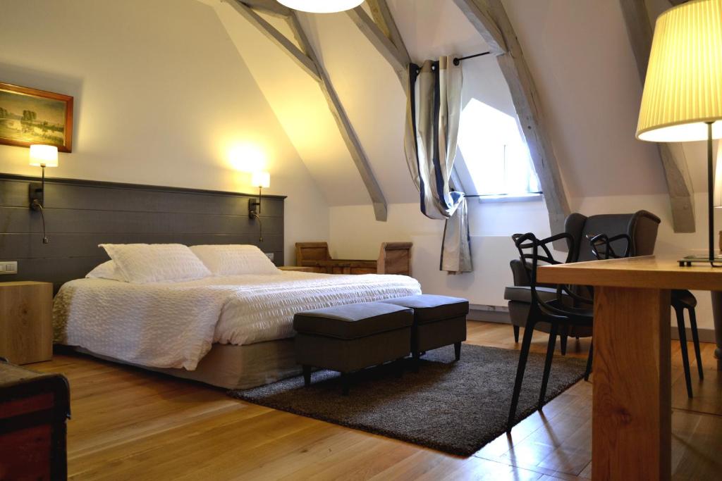 sypialnia z łóżkiem, stołem i krzesłami w obiekcie La Maison Des Jardins w mieście Auriac