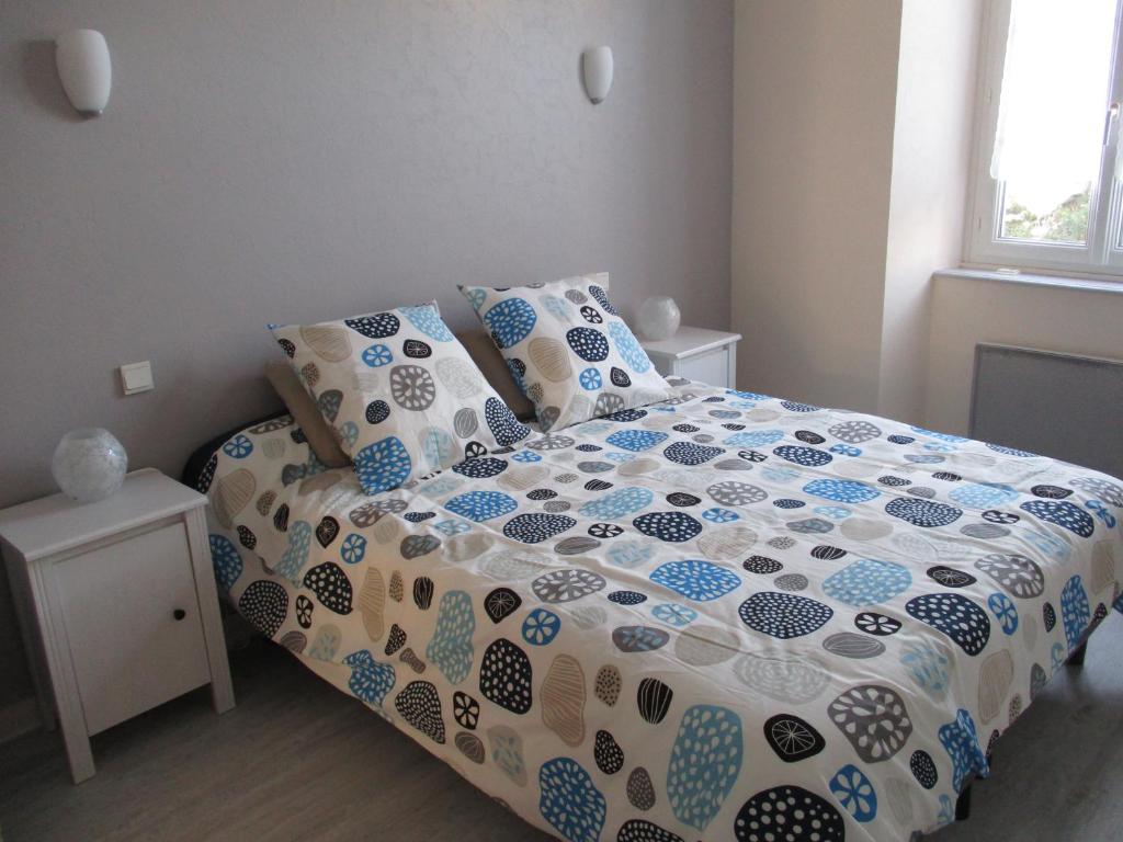 una camera da letto con letto e lenzuola e cuscini blu e bianchi di Appartement Clémenceau a Saint Malo