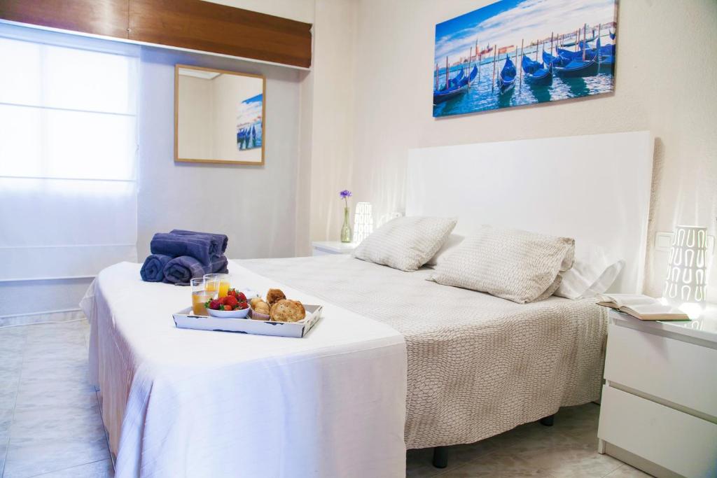 バレンシアにあるApartamento Cardenalのベッド1台(食料品のトレイ付)が備わる部屋