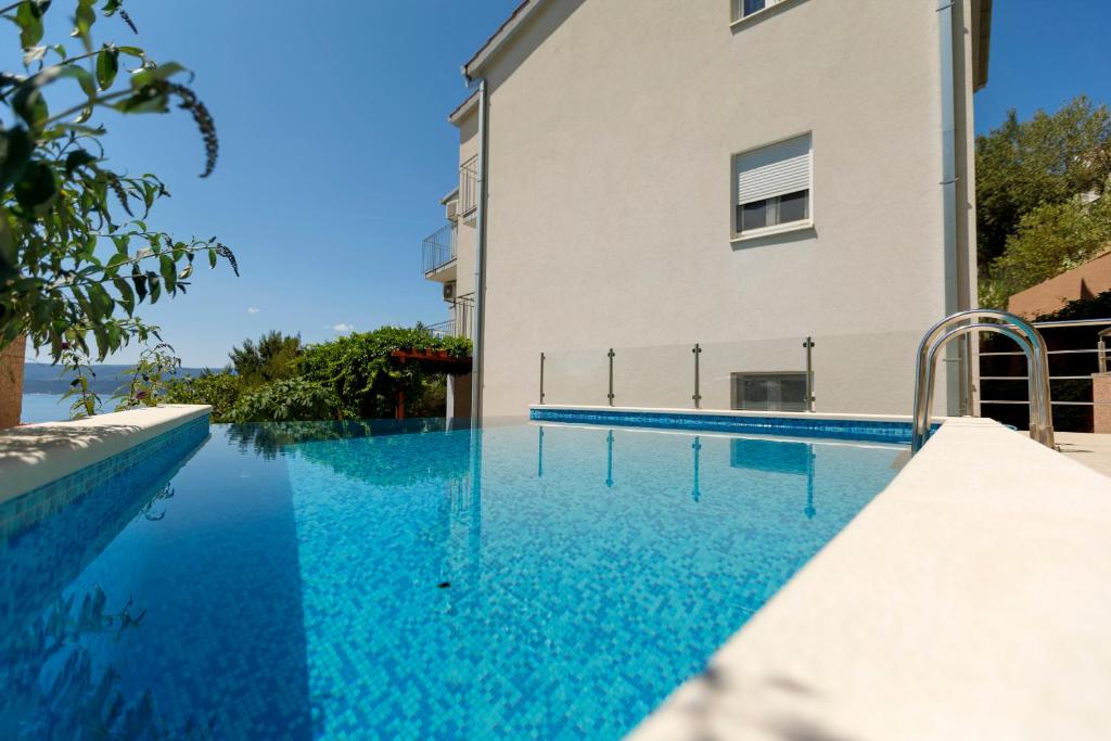una piscina junto a un edificio con agua azul en Apartments Sara & Nina, en Omiš