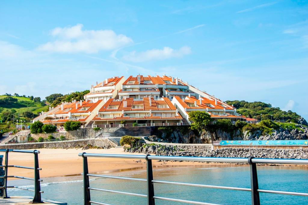 a building on a beach next to the water at Playa De Arnadal Isla in Isla