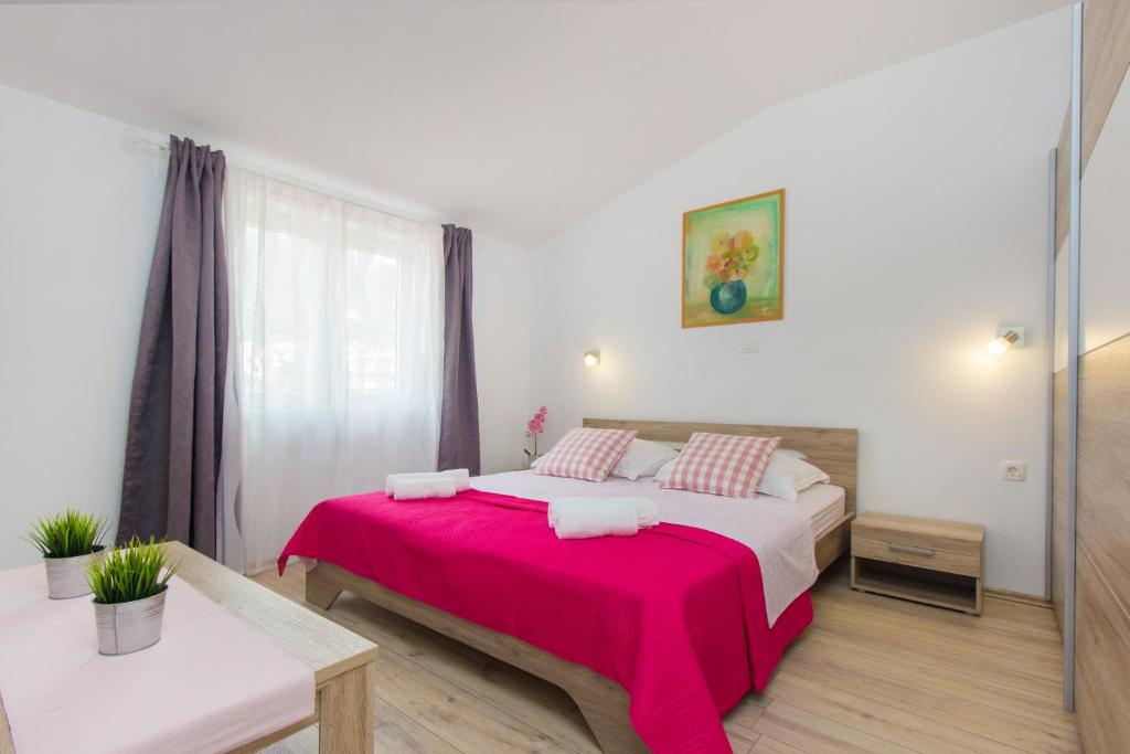 a bedroom with a large bed with a red blanket at Luxury Apartment Ante in Kaštela