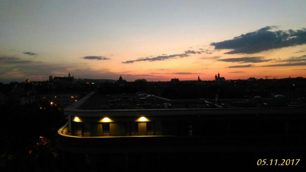 widok na miasto o zachodzie słońca z budynkiem w obiekcie DRAGON Apartments (Helena) w Krakowie