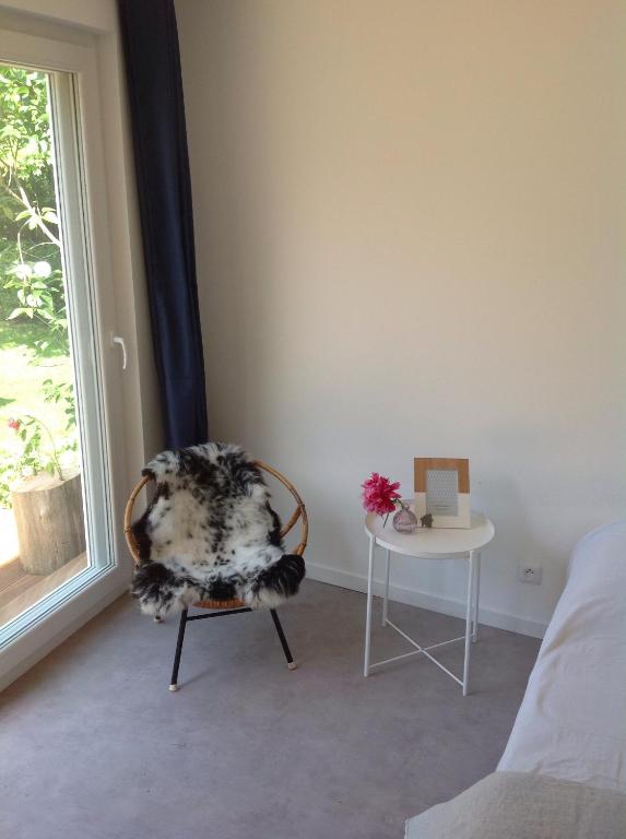ヴィムルーにあるJardin au bord de merの椅子とテーブル、窓が備わる客室です。