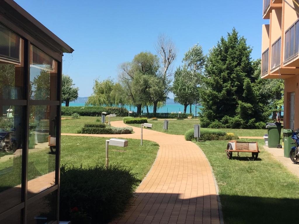 a walkway through a park next to a building at Cuki Apartmanok in Si&oacute;fok