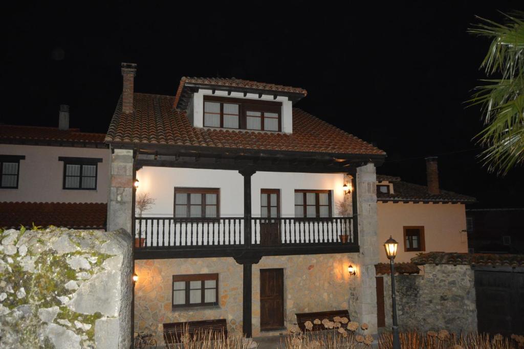 a large white house with a balcony at night at Casa Coxiguero in Parres de Llanes