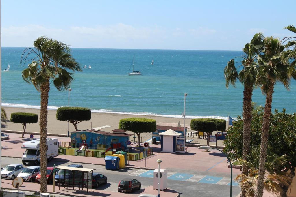 einen Strand mit Spielplatz, Palmen und dem Meer in der Unterkunft Playa Viginia in Málaga