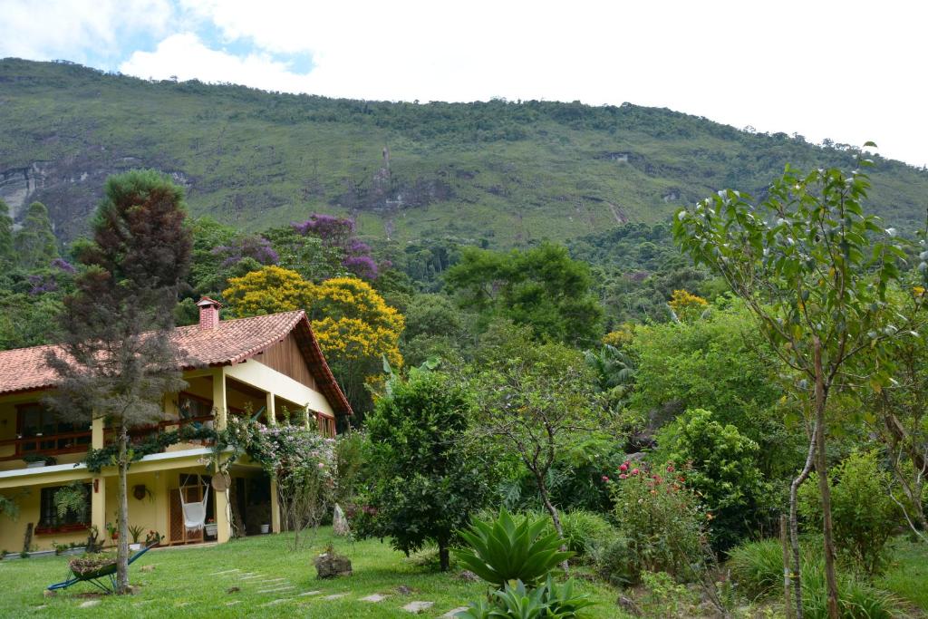 a house with a mountain in the background at Pousada Ribeirao da Floresta in Lumiar