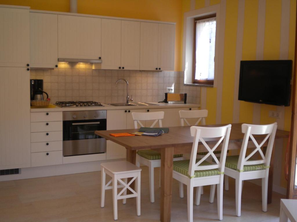 a kitchen with a wooden table and white cabinets at Appartamenti Girasole in Cannobio