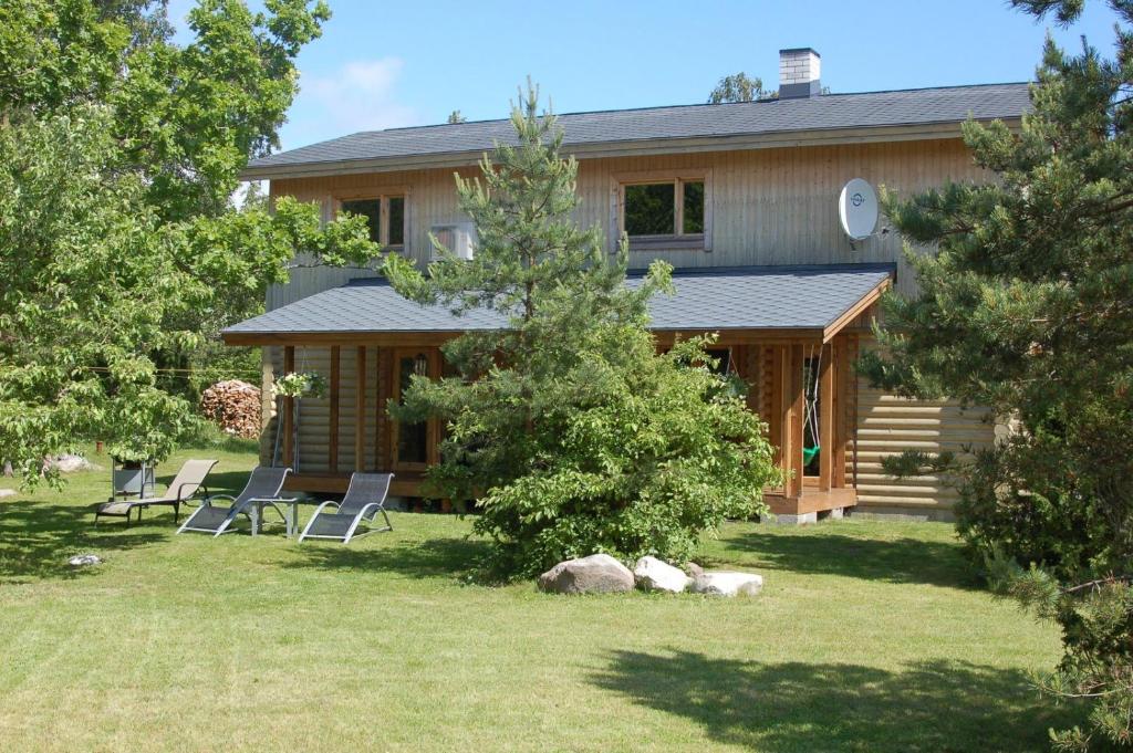 a house with chairs and a table in the yard at Kibuvitsa Holiday House in Muratsi