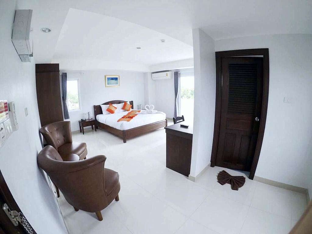 een slaapkamer met een bed, een bank en een stoel bij Sunrise Inn in Krabi town