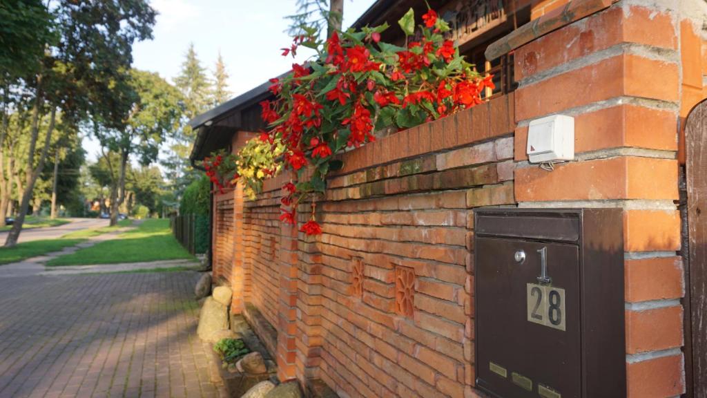 Una pared de ladrillo con flores rojas. en Pas Birute, en Kaunas