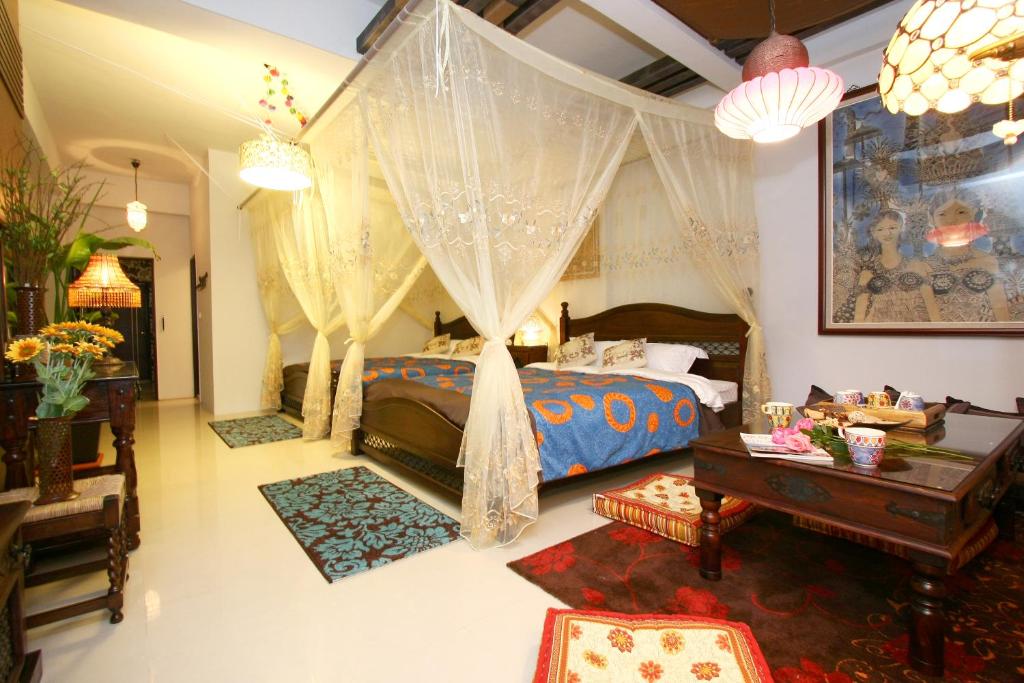 a bedroom with a bed and a table in a room at Kimoge Homestay in Hualien City